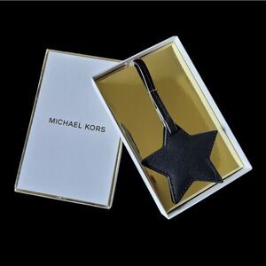 MK black leather star luggage charm